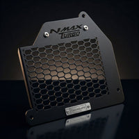 Close-up studio shot of the CustomradPH Yamaha NMAX Tech Max Radiator Cover. This black powder-coated CNC steel motorcycle accessory features an aggressive honeycomb mesh design, a precision-cut NMAX TURBO logo at the top, and a brushed metal CustomradPH badge at the bottom, showcasing its premium exterior styling and durable construction.